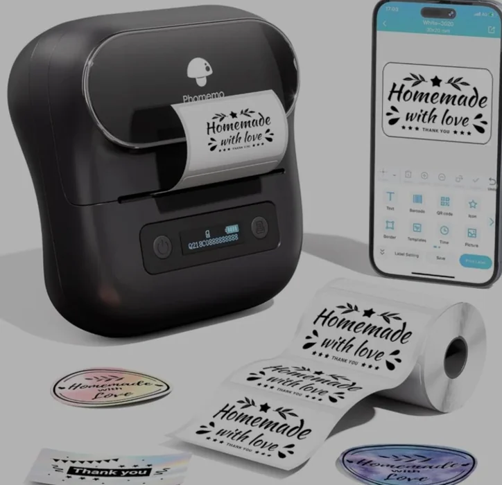 Compact Bluetooth label printer beside a phone and a roll of labels